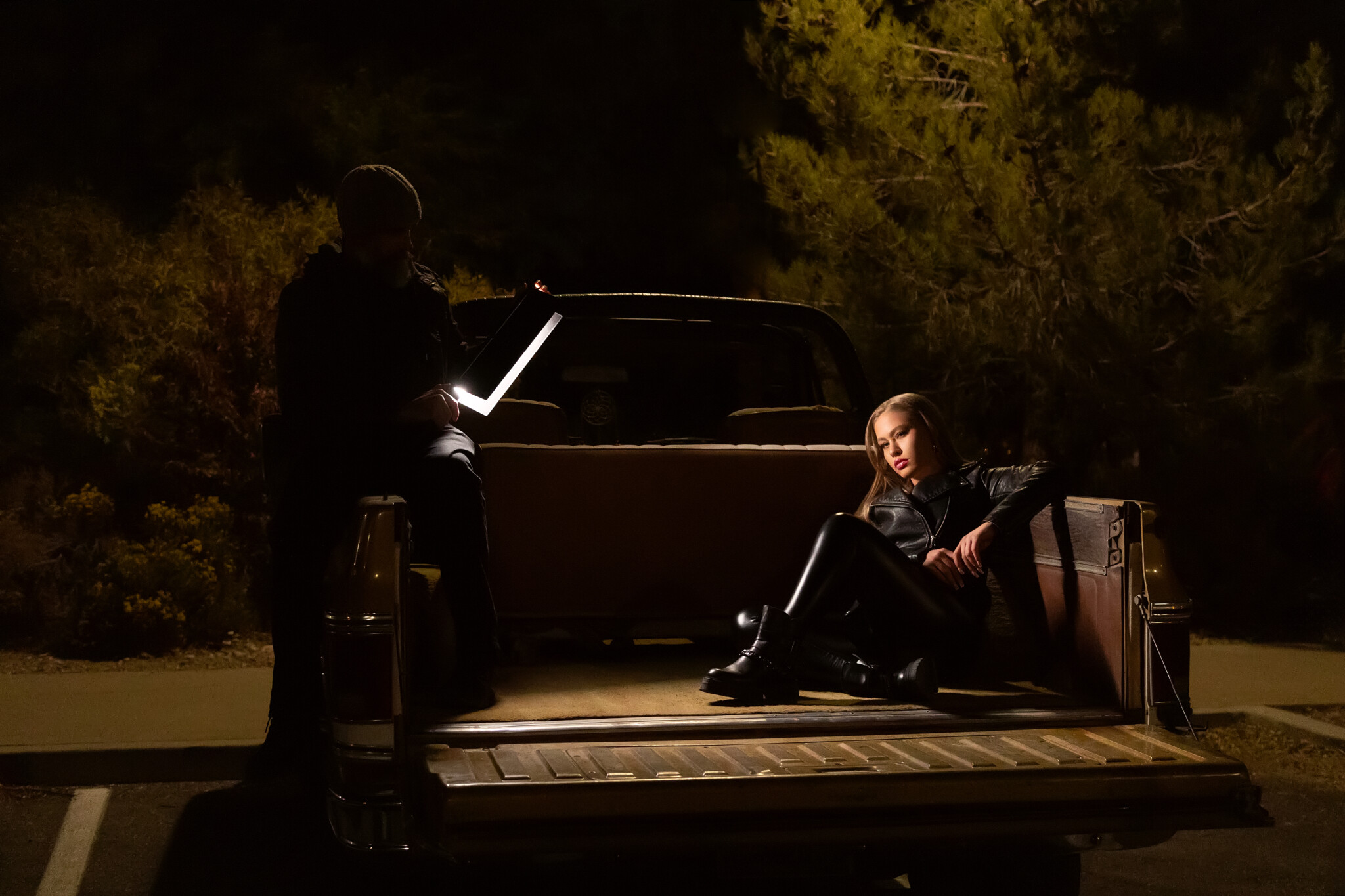 Women in all black sitting in a truck bed at night