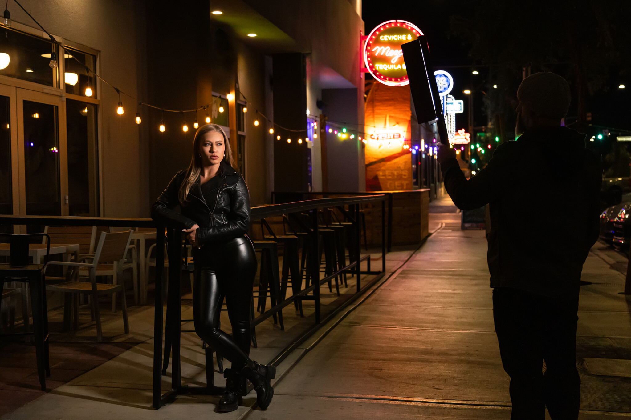 Behind the scenes of a women with blond hair and all black posing