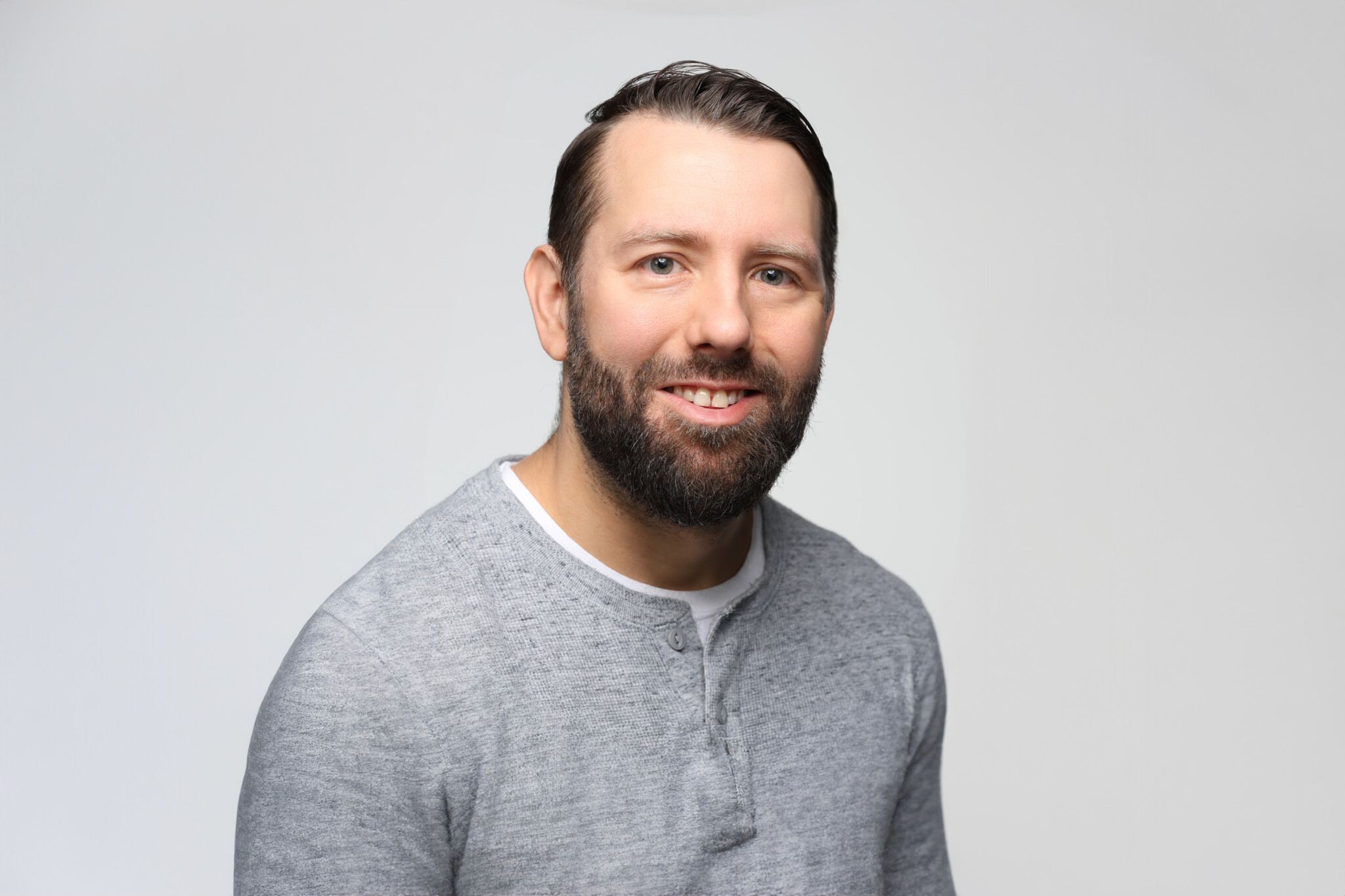 Man with a white background smiling
