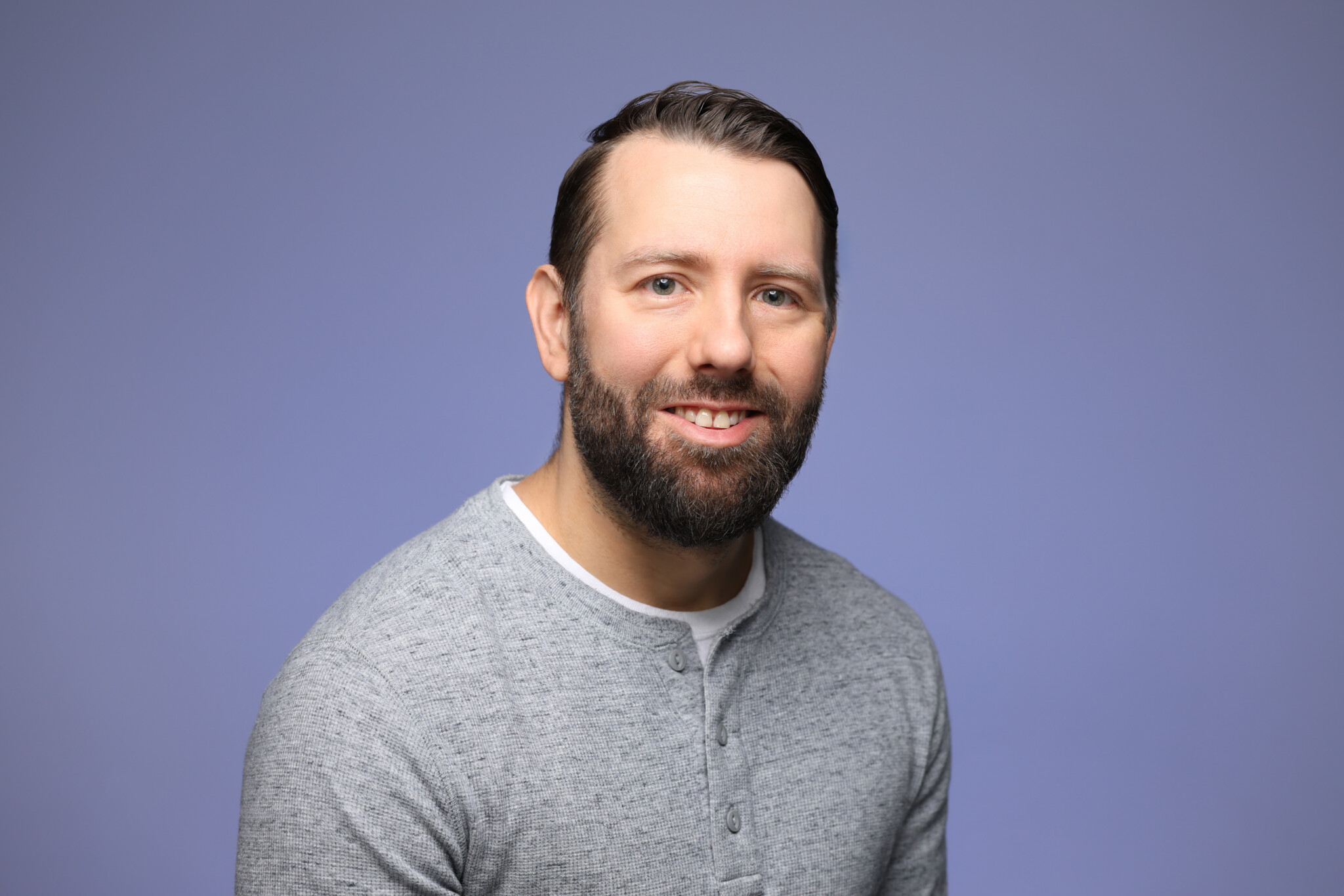 Man with a blue background smiling
