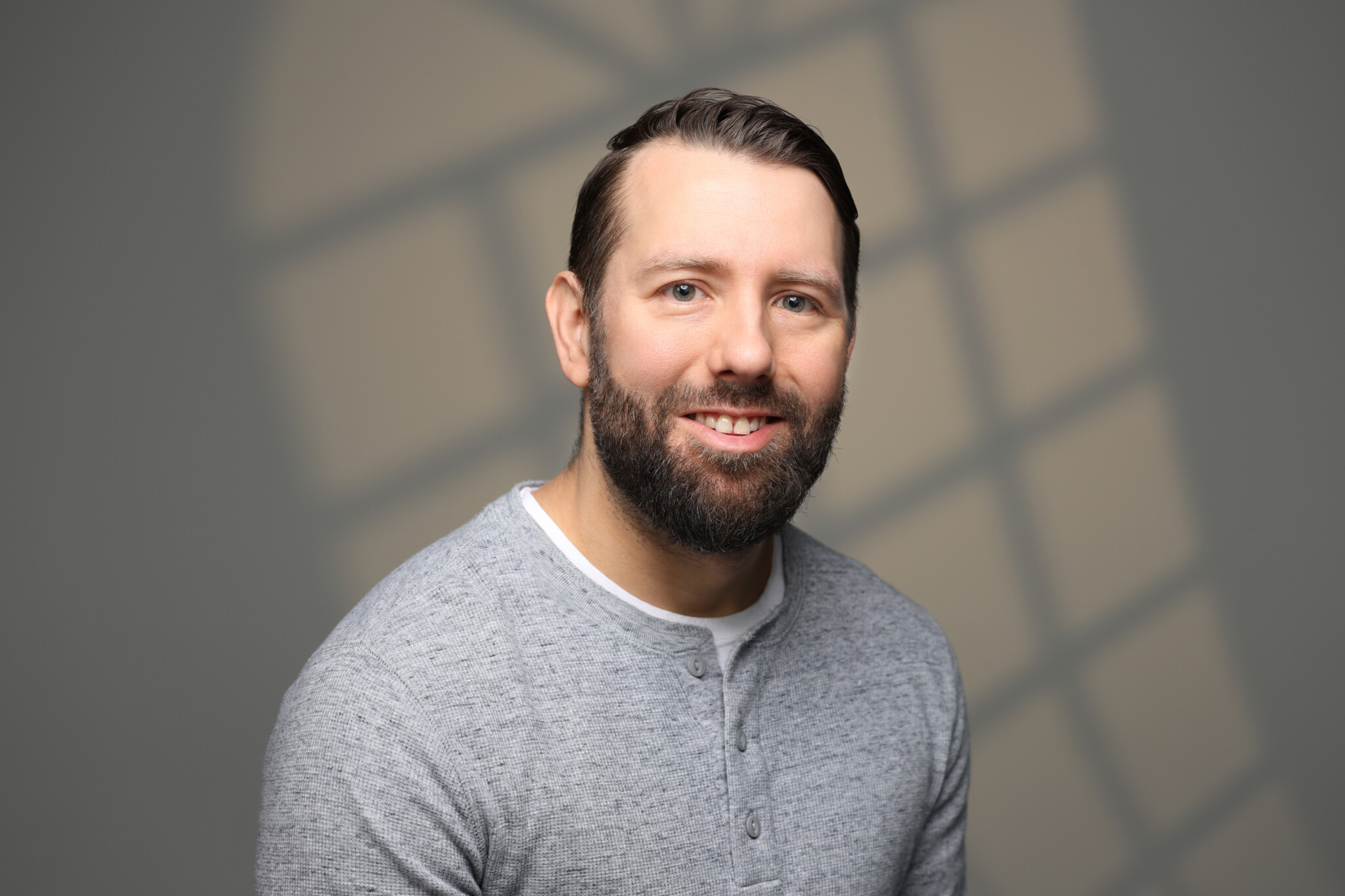 A man smiling with a window lighting effect