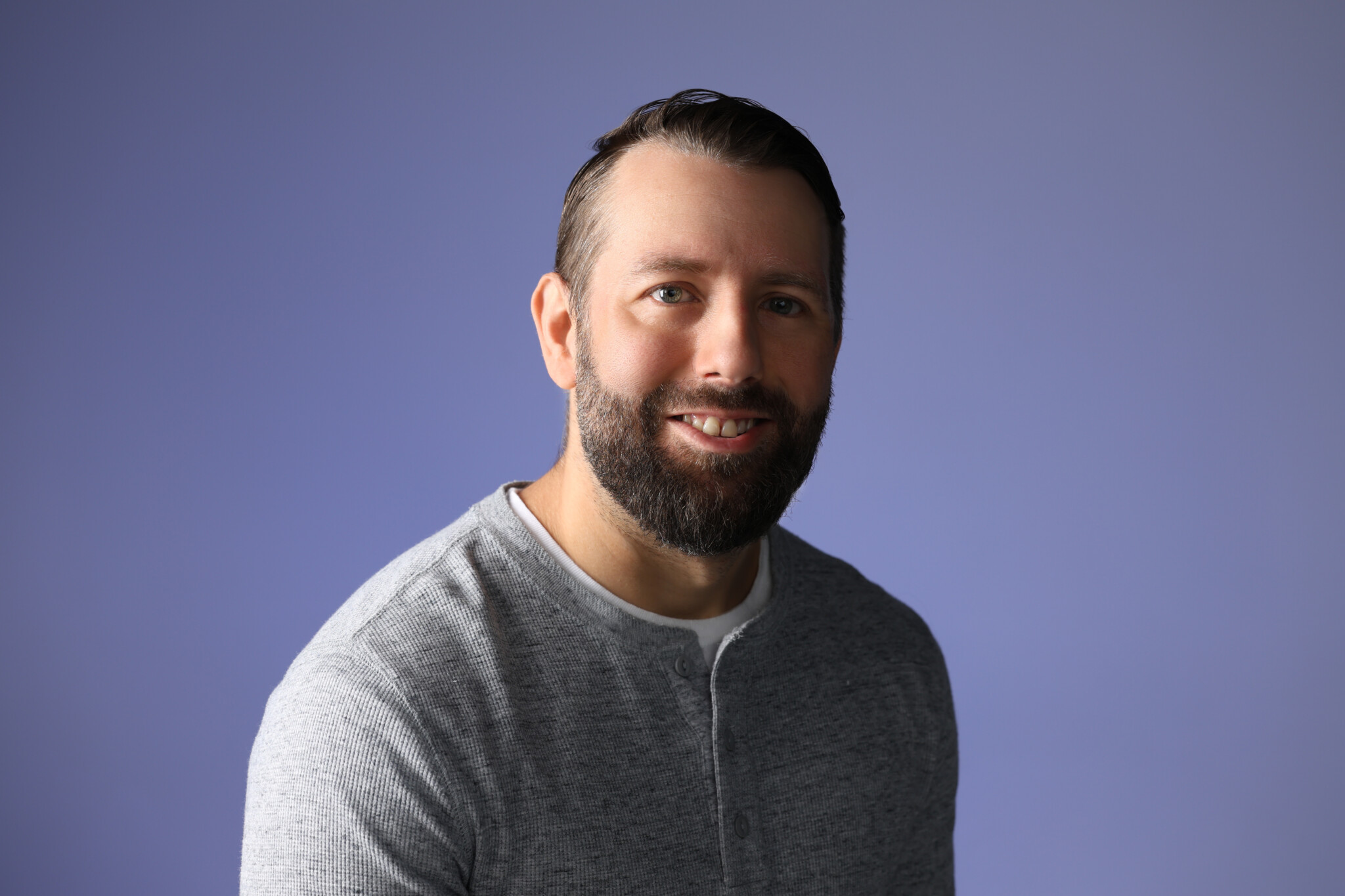 Darker picture with Man with a blue background smiling