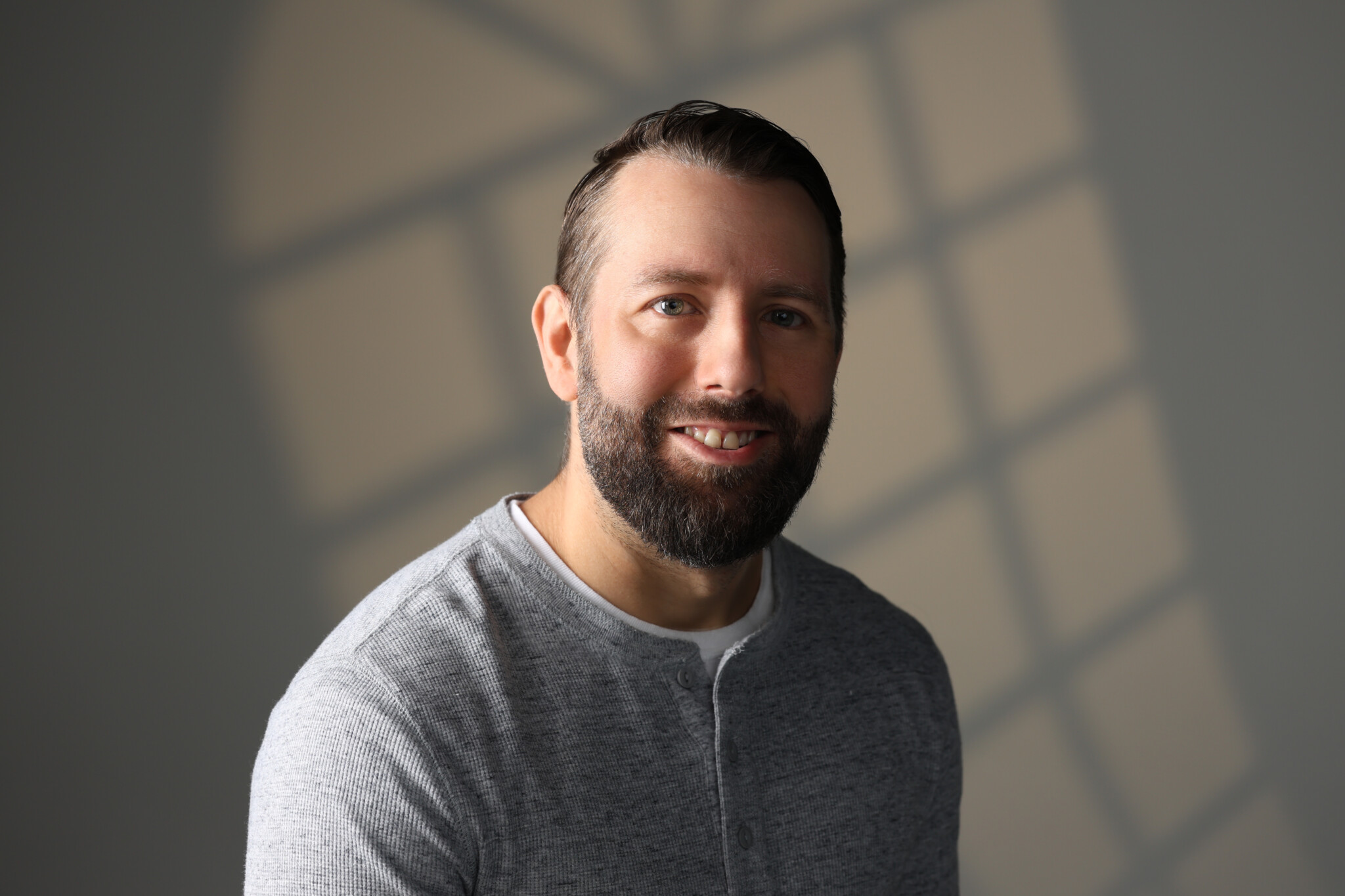 Darker picture with a man smiling with a window lighting effect