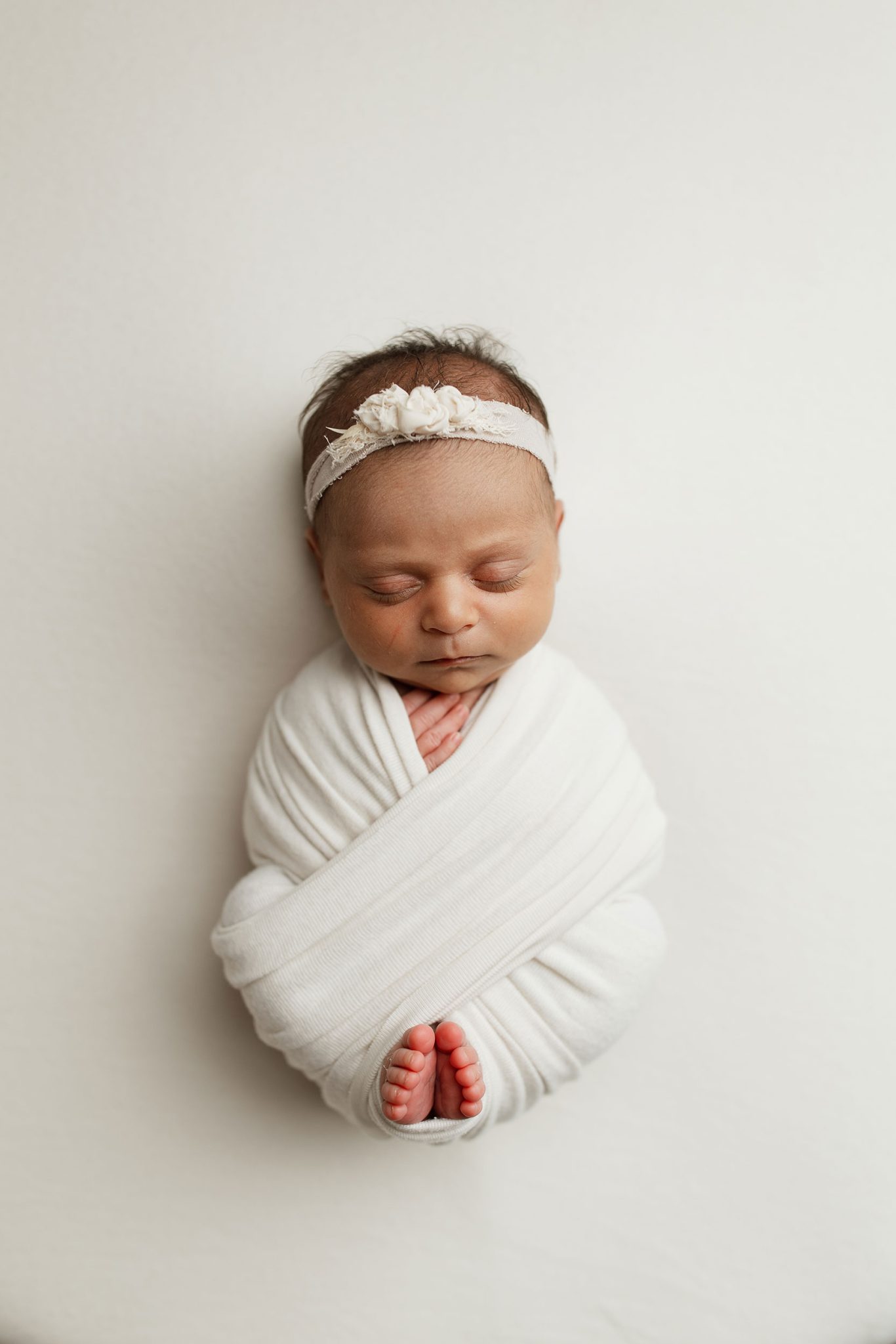 The 7-ft umbrella with two layers of diffusion softens the light from the FJ400 II for smooth, even newborn lighting.