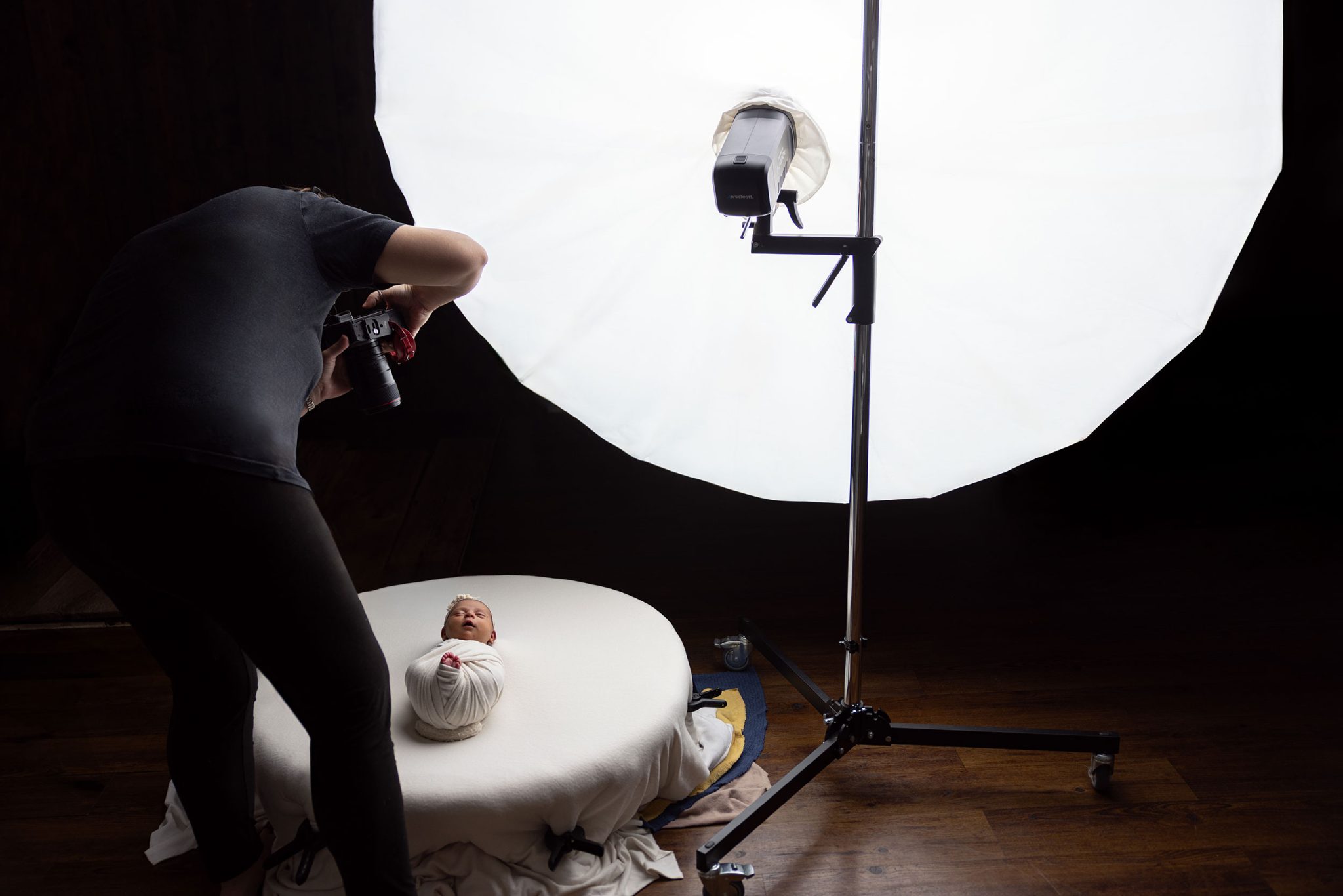 Studio setup showing light placement above the baby for natural, top-down lighting.