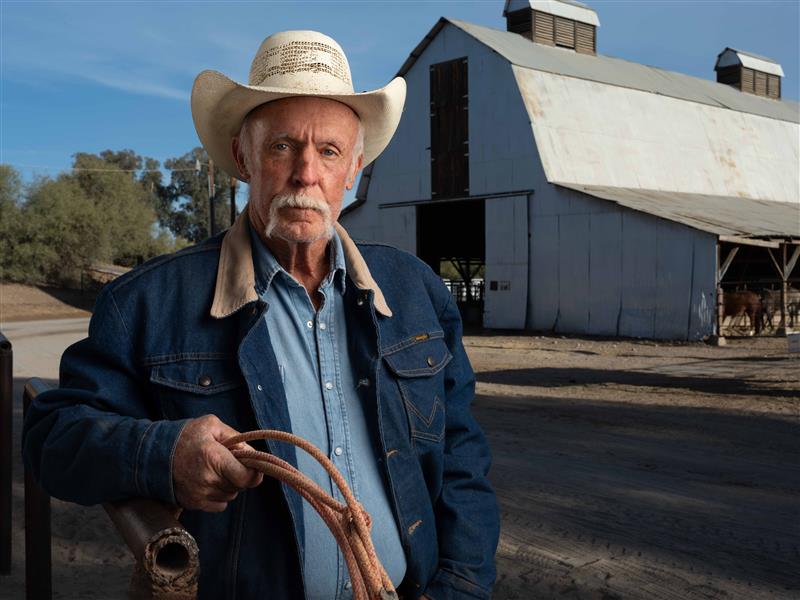 Portrait with a deep depth of field Older man wear a cowboy hat and holding a lasso