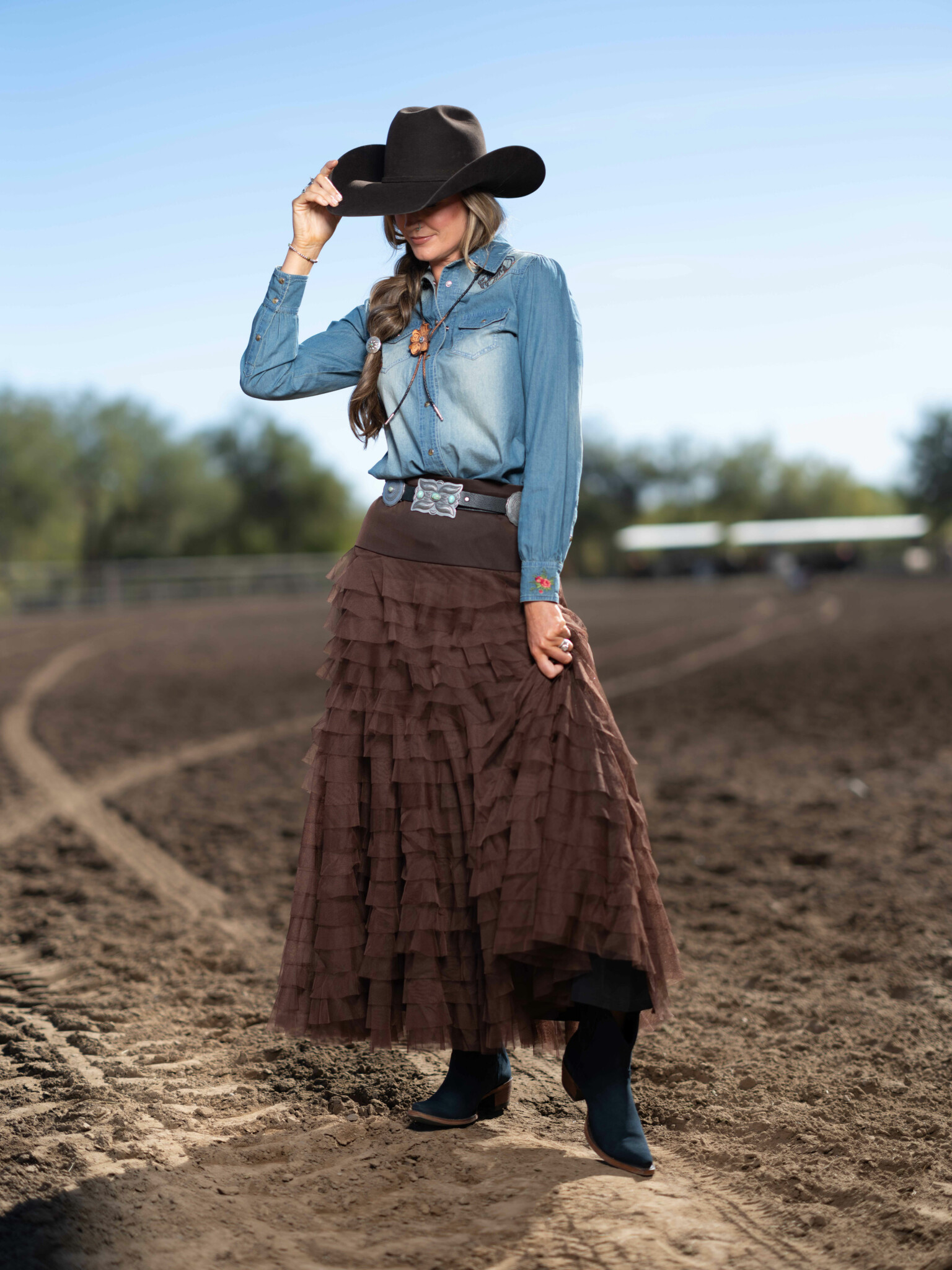 Portrait shot at 1/4000 shutter speed woman holding hat down to cover face full sun