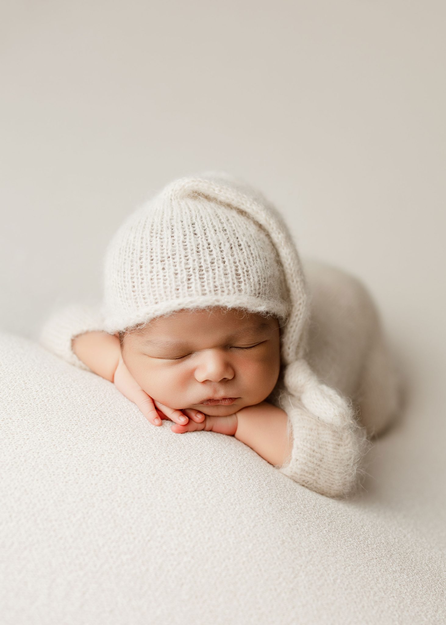 Classic tabletop newborn pose using one-light setup for clean, consistent results.