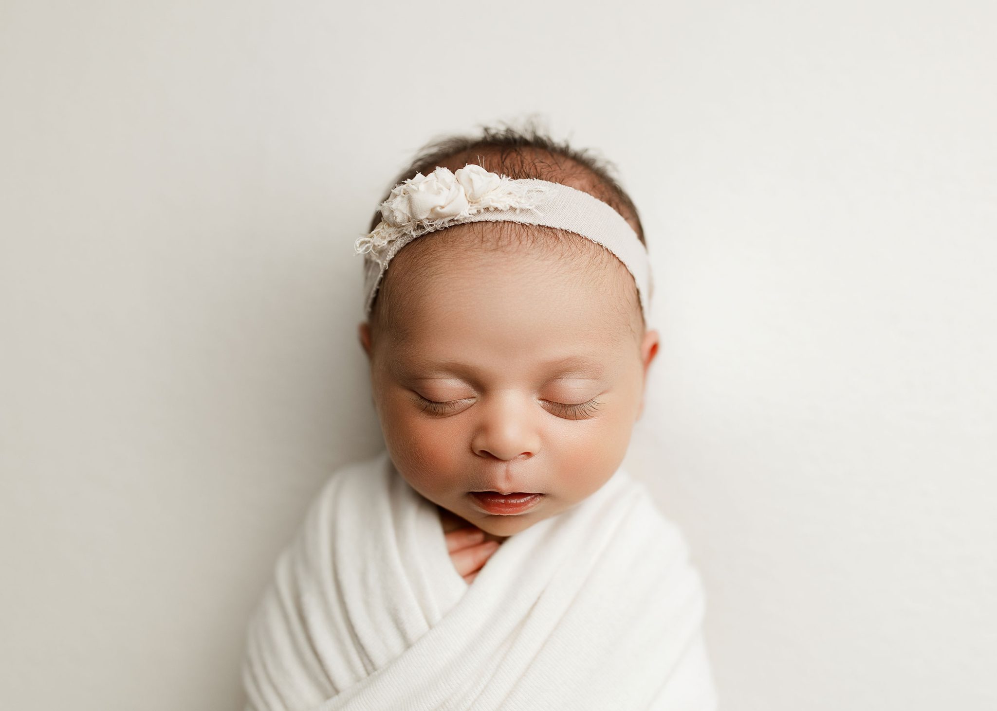 Wrapped Posing Final Photo uses one FJ400 II and 7-ft umbrella for flattering light on the baby’s face.