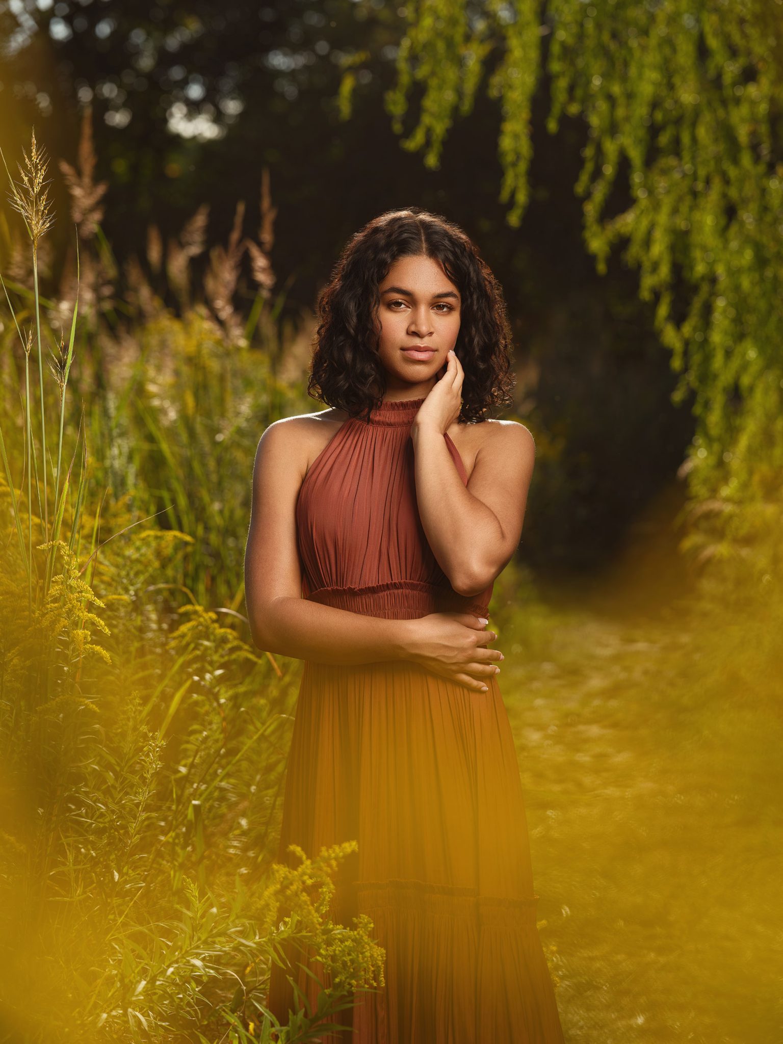 Golden hour portrait with flowers in the foreground to add depth, softness, and a warm natural glow.