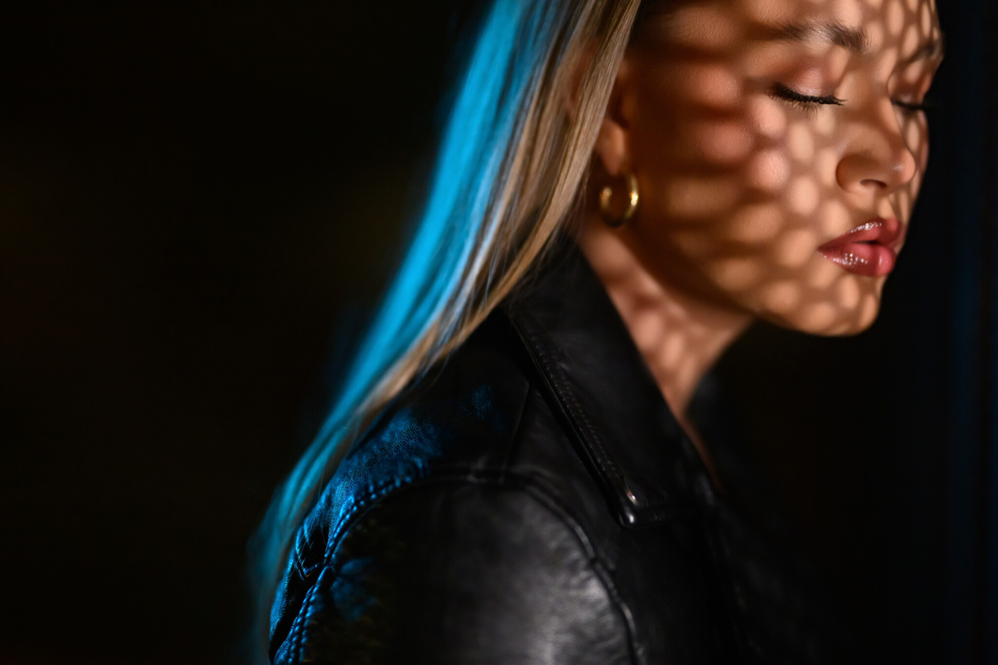 Blond woman staring away from the camera with intense shadows on her face