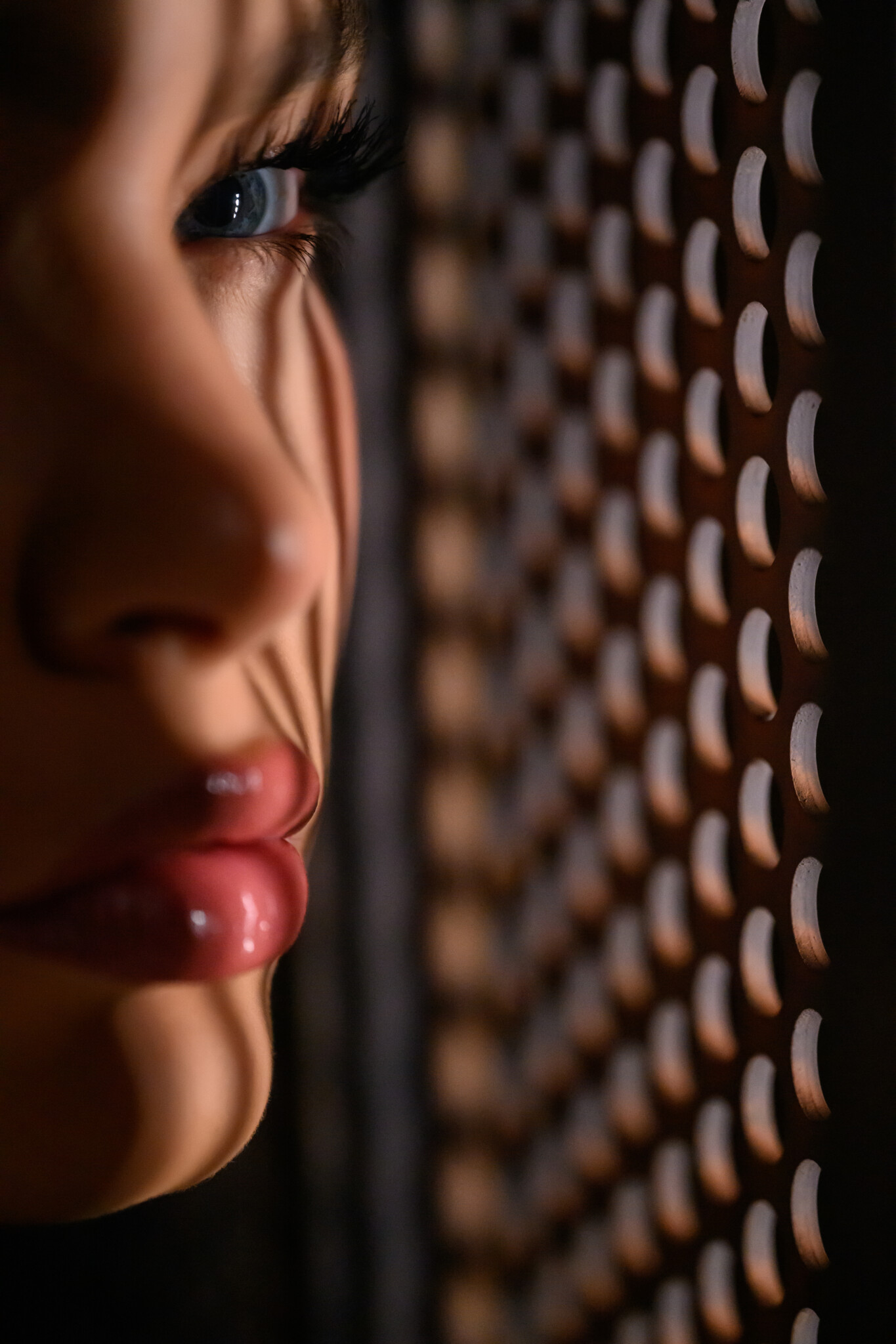 Close up of a woman's face next to a grate