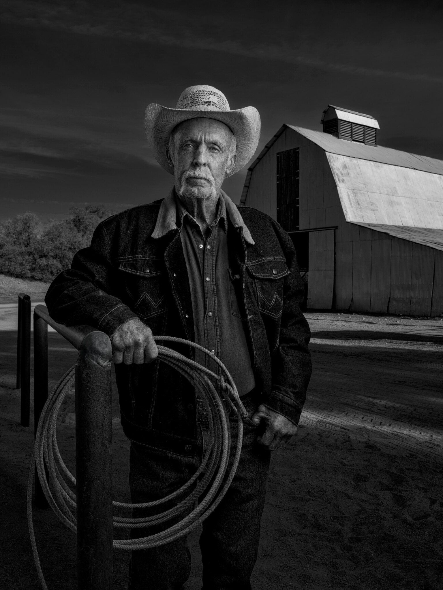 Black and white portrait of Larry Simpson lit with two FJ800 strobes Older man wearing a cowboy hat in black and white holding a lasso