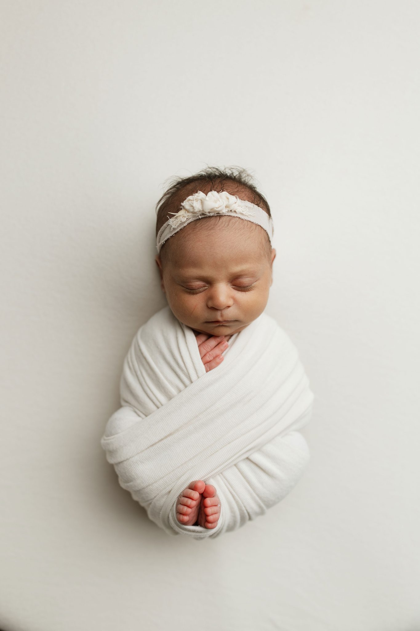 Top-down angle highlights the baby’s features naturally and keeps focus on the face.