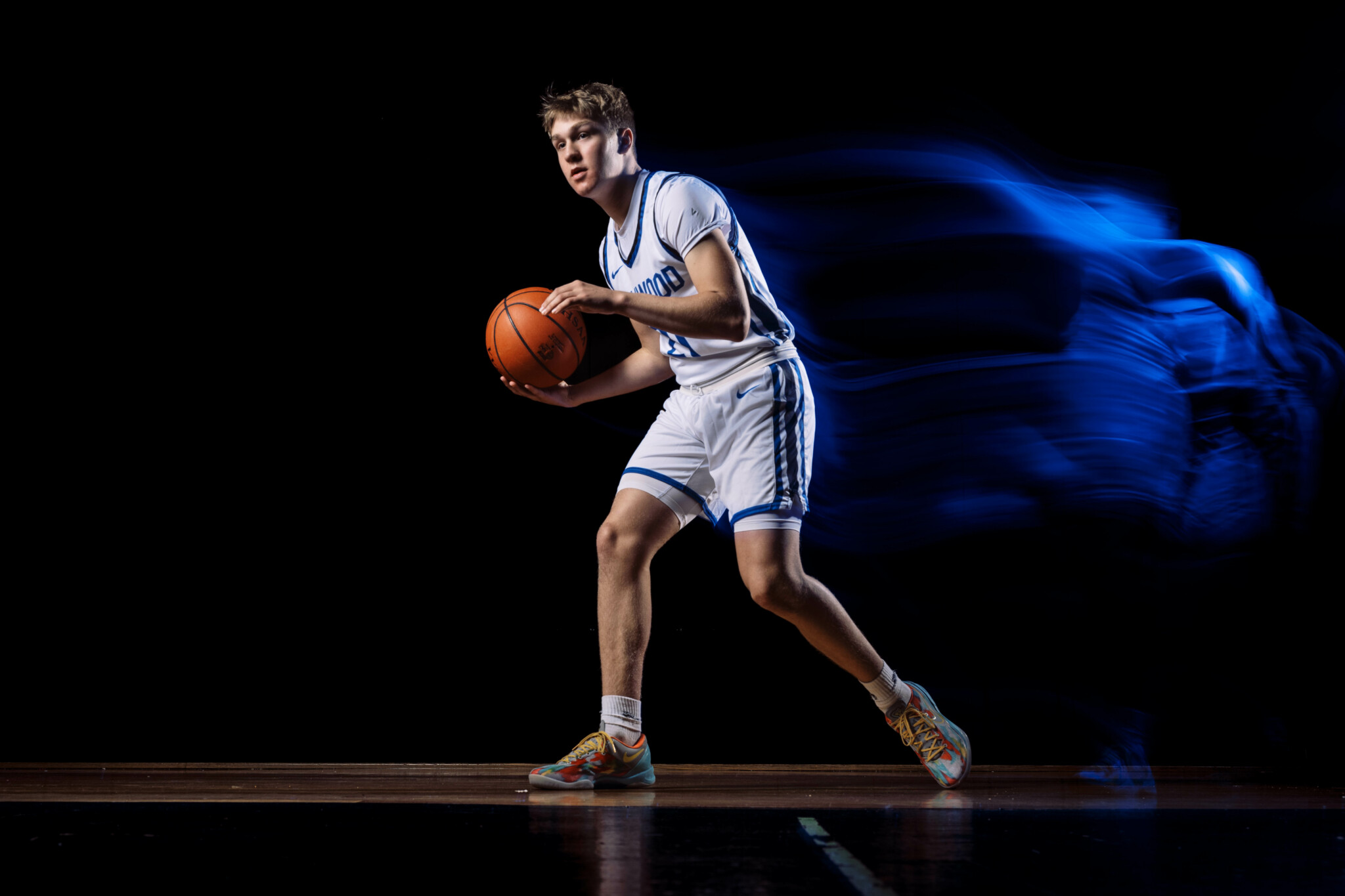 FlasSet to Front Curtain Sync Basketball player holding a ball with light trails behind him