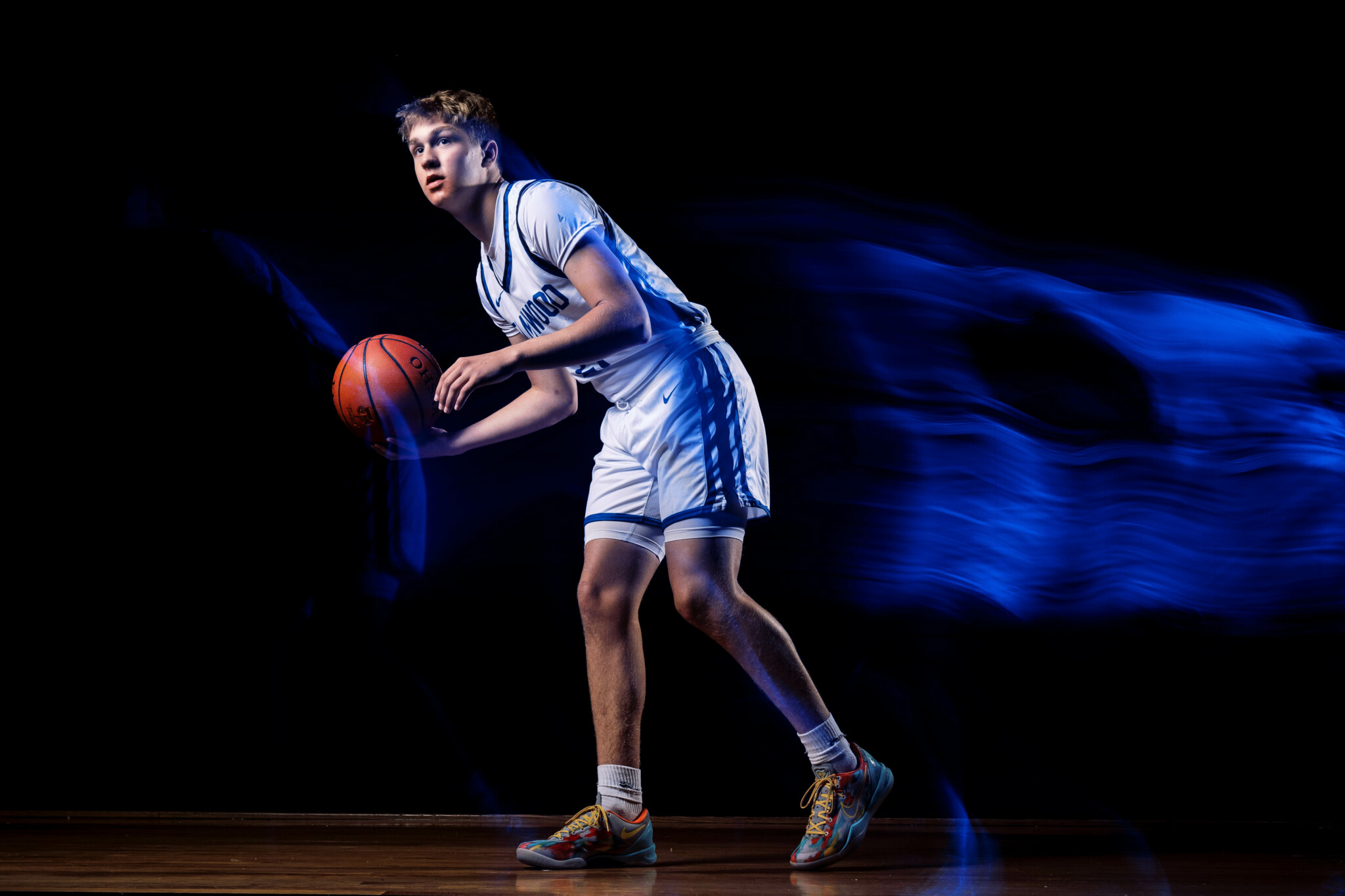 Light Trails with Controlled Ambient Lighting Basketball player holding a ball with controlled light trails.