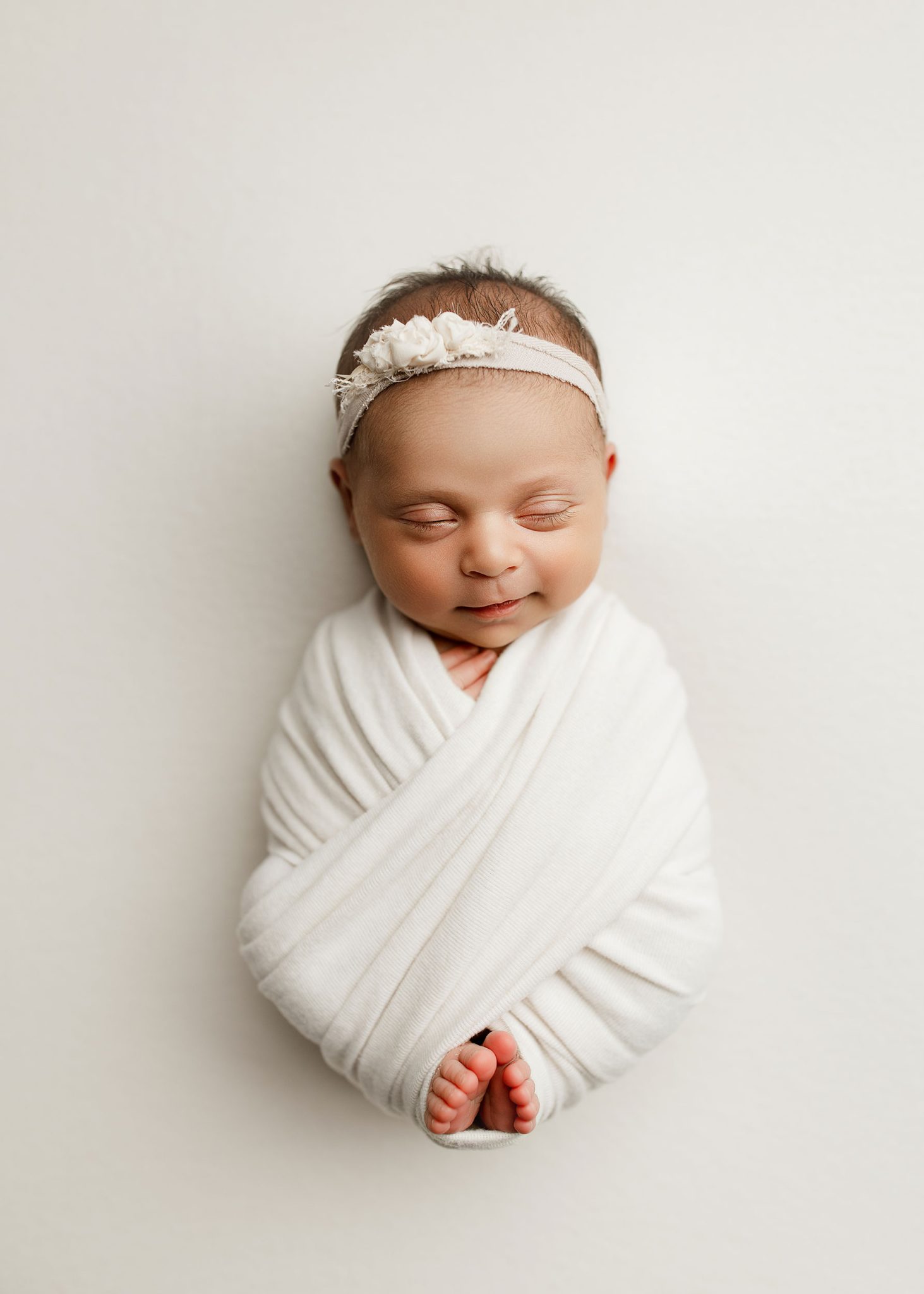 Simple one-light setup creates gentle, flattering light for this wrapped newborn portrait.