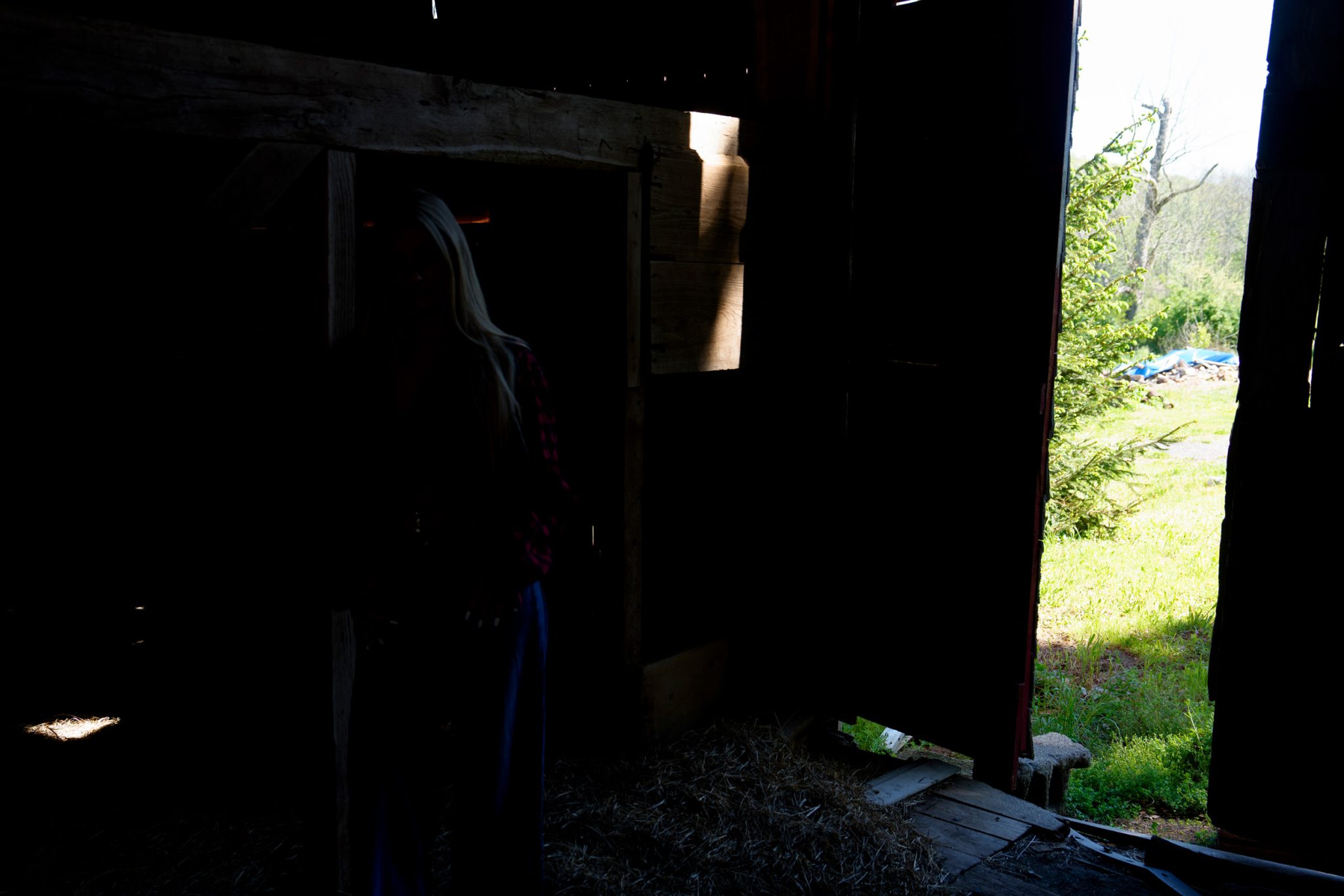 Ambient light only leaves the subject dark against the bright barn doorway.