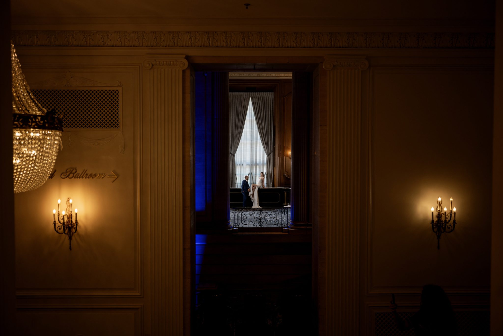 Wide portrait uses three-point lighting to keep the couple bright within the dark space.