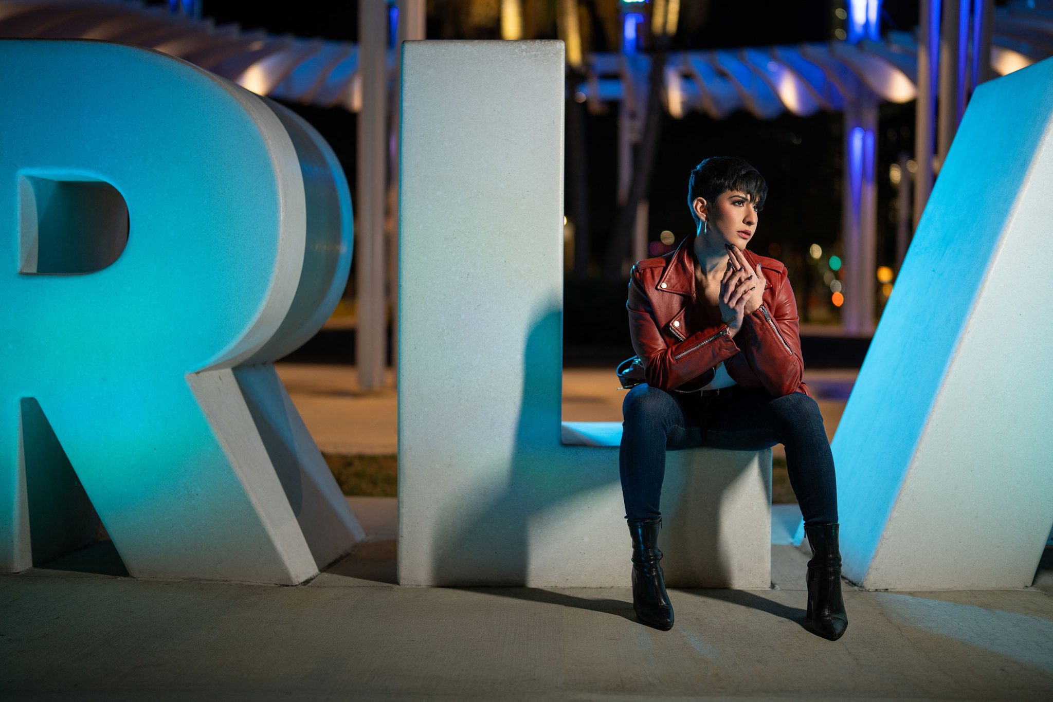 Night portrait using the Ice Light 3 to highlight the subject against a glowing letter sign.