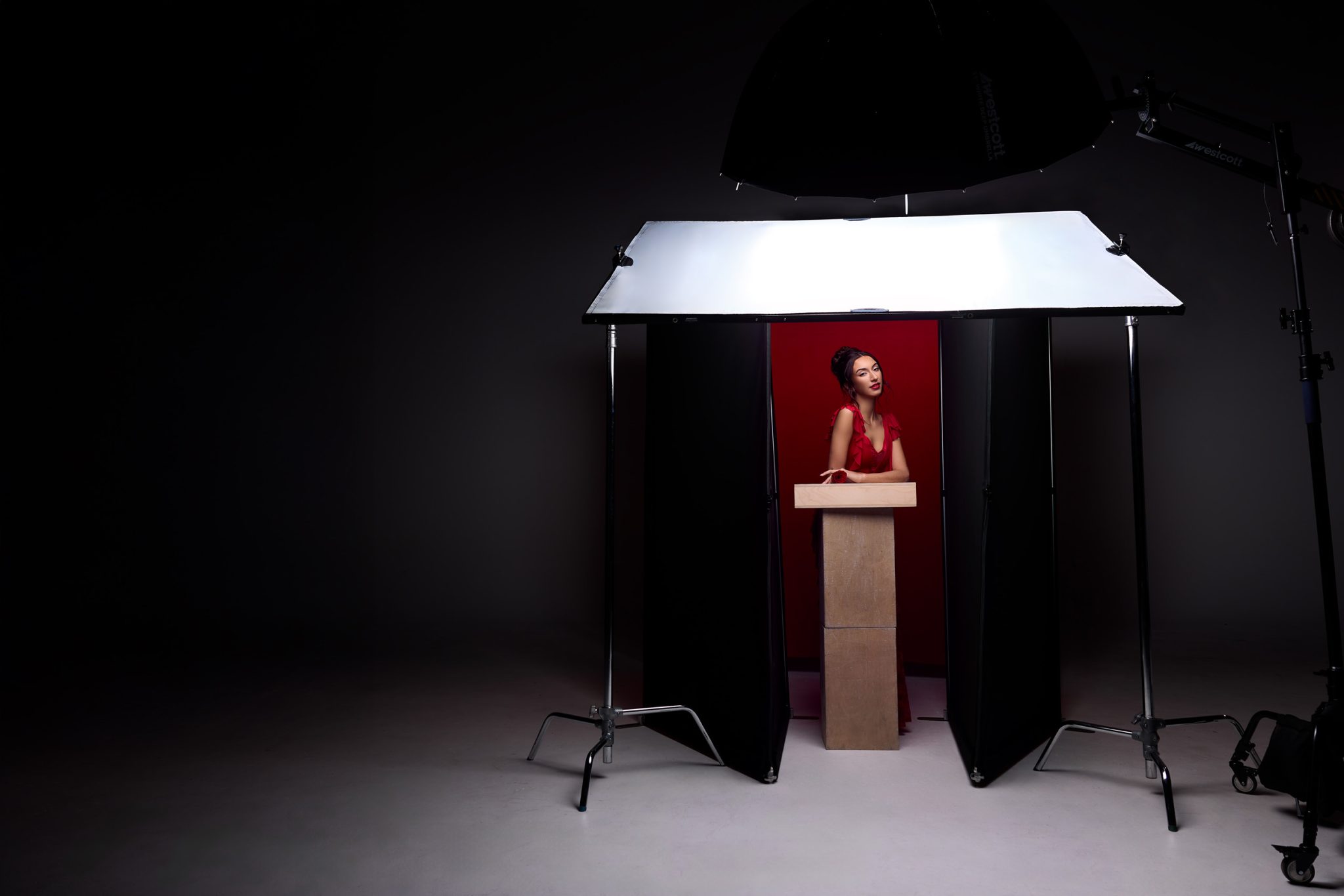 Behind the scenes shows the black V-Flat placed close to the subject to deepen shadows.