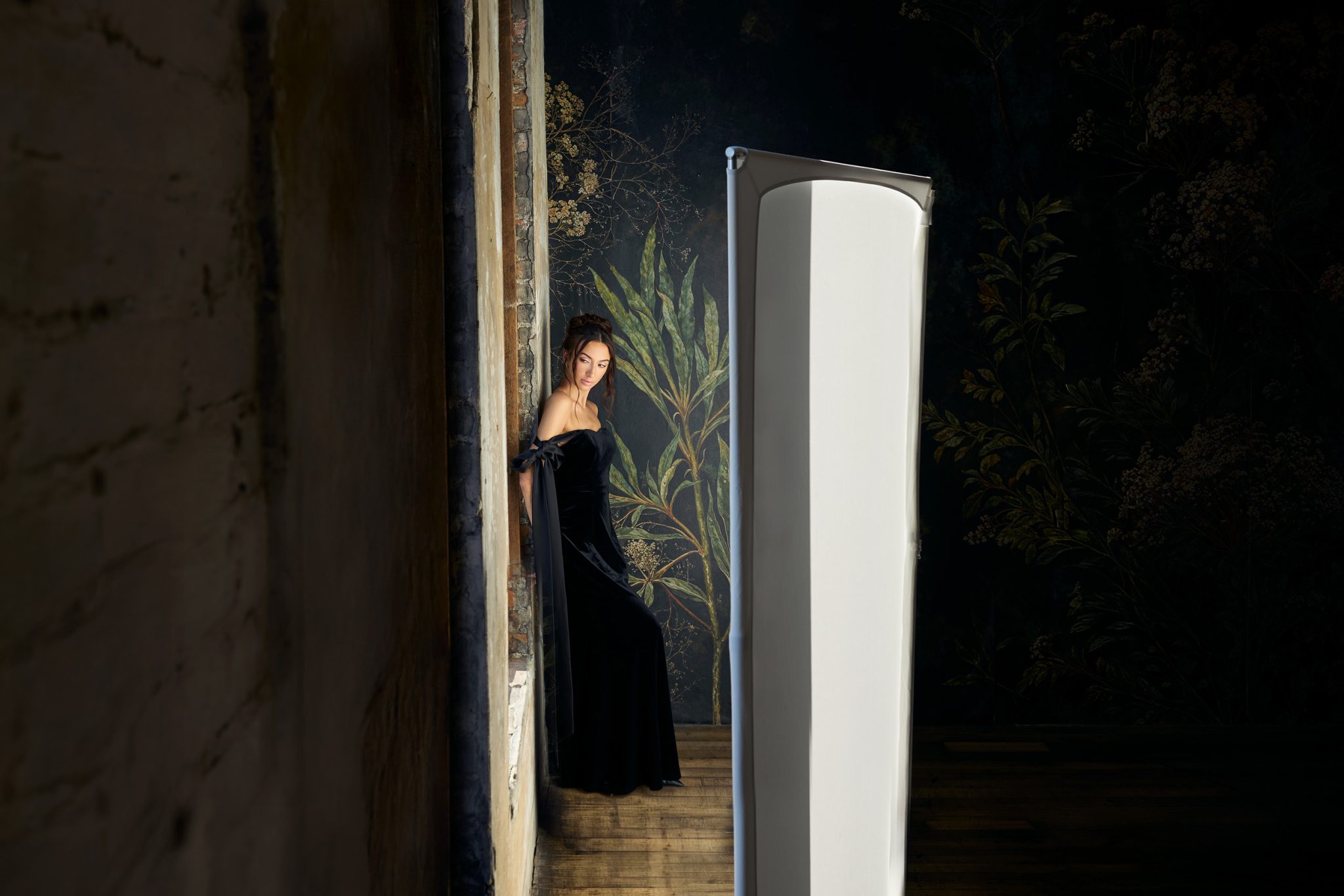 Behind the scenes shows the white Westcott V-Flat bouncing window light back onto the subject.