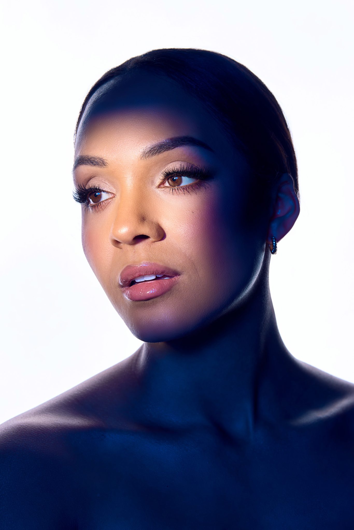 Dramatic beauty portrait lit using an FJ800 with Optical Spot for a focused beam of light and high contrast.